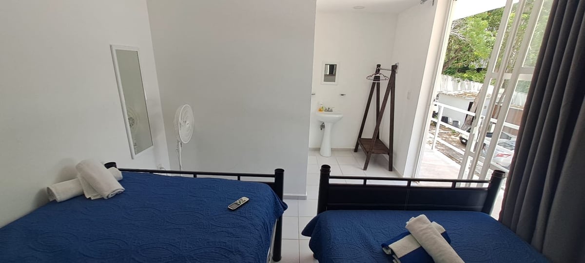 Habitación familiar con dos camas matrimoniales con colchas azules